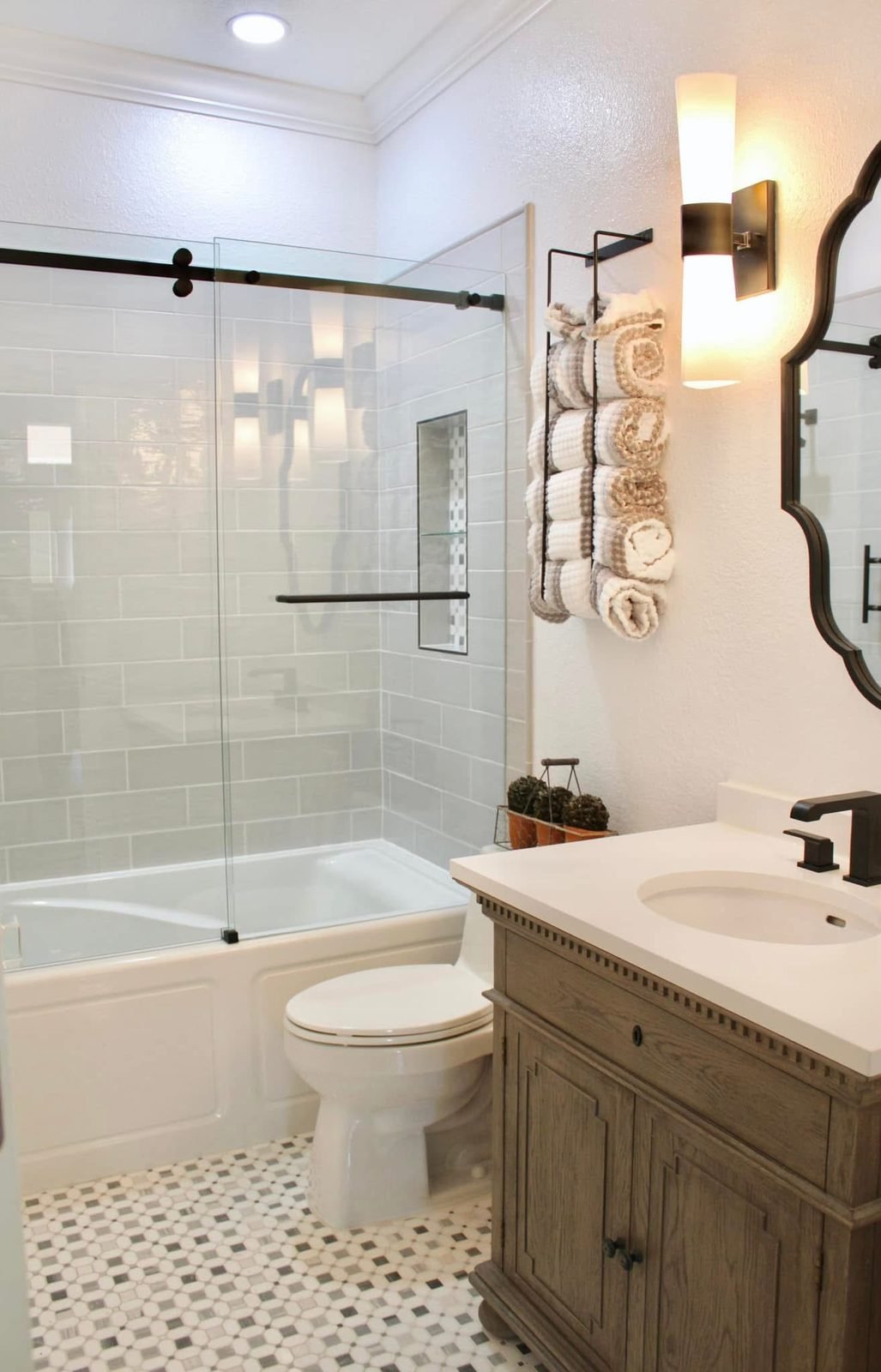 Custom bathroom remodel in Auburndale, Florida by Merritt's Affordable Services — featuring walk-in glass shower, mosaic tile flooring, and custom wood vanity