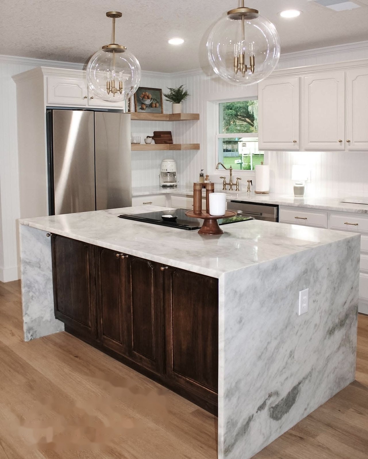 Luxury kitchen remodel in Lakeland, FL with waterfall marble island and globe pendant lighting